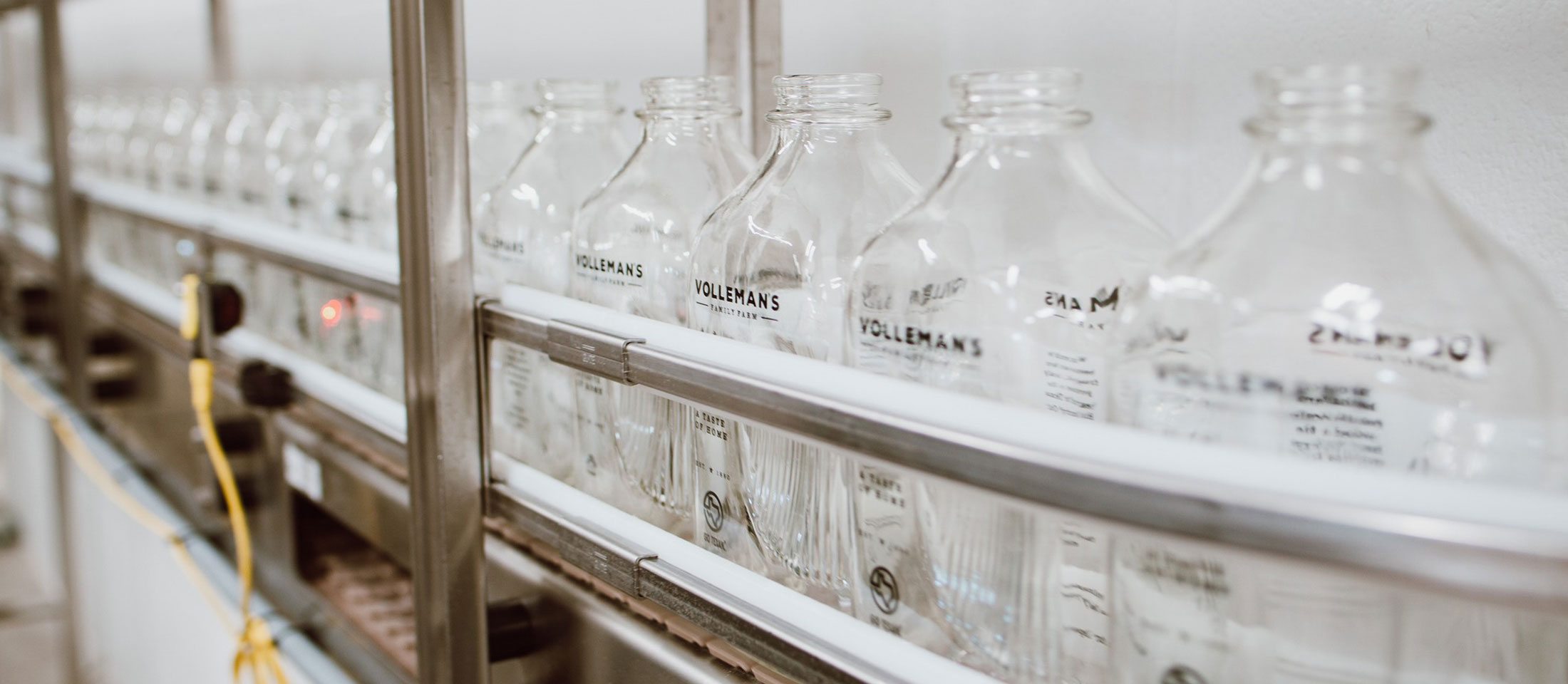 Glass bottles on the bottling line about to get filled with milk